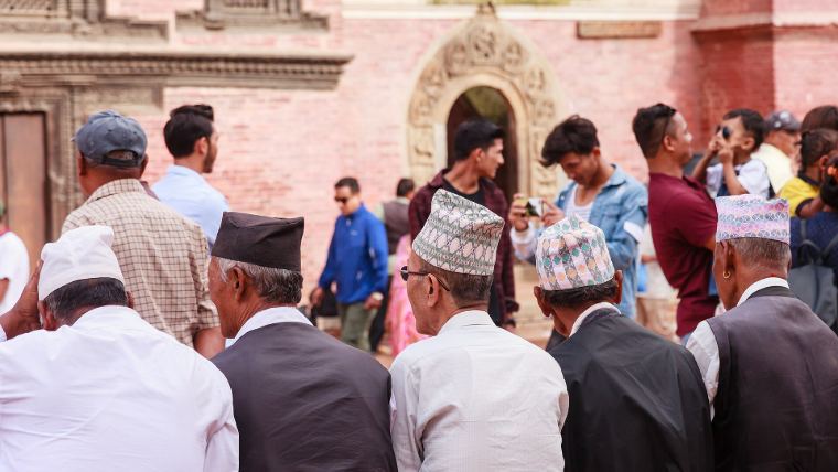 Older Newar men in dhaka topi gathered at Patan Durbar Square